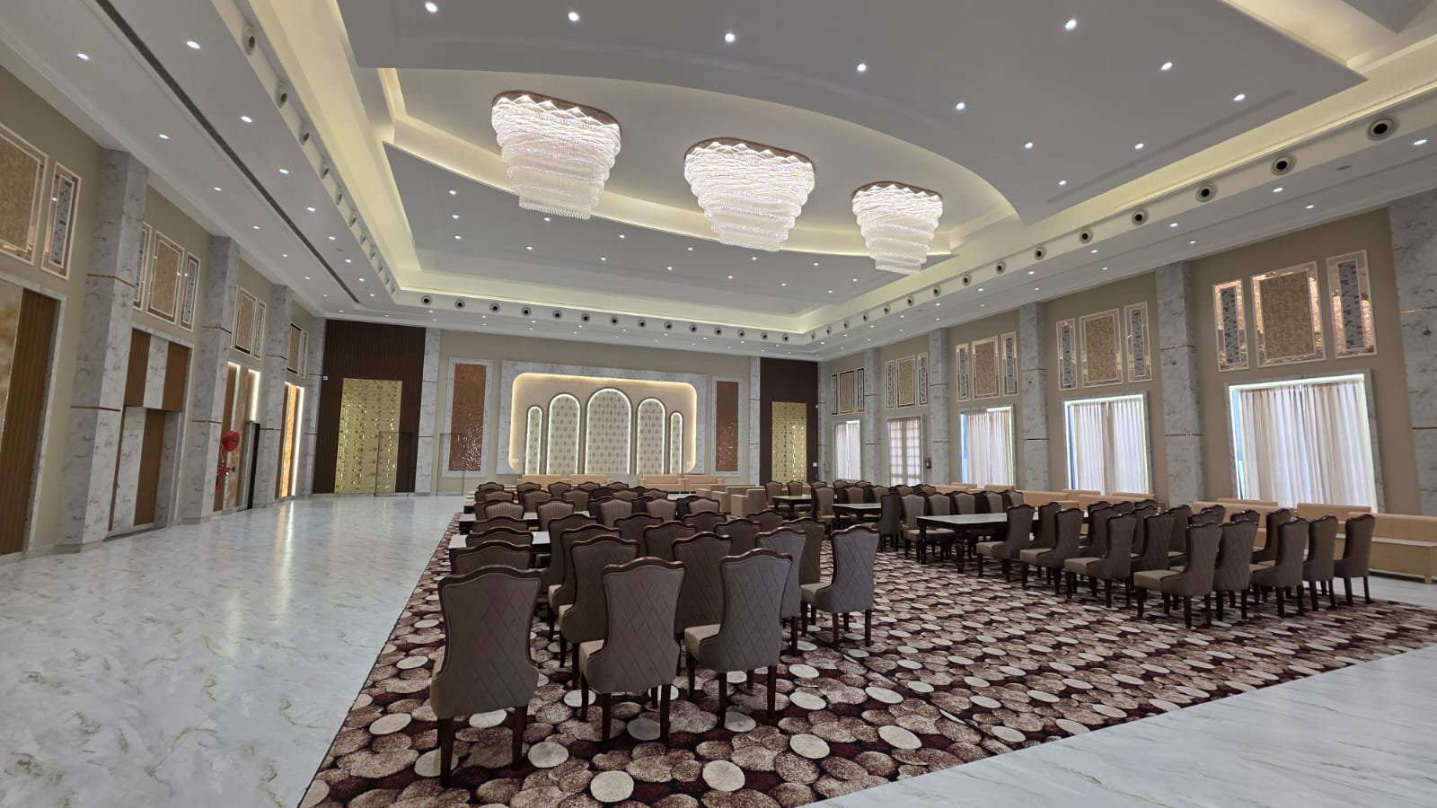 Grand hall with decorated stage and chandeliers